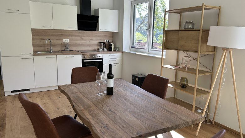 Interior view of a modern kitchen with dining table and chairs.
