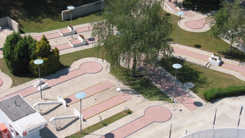 Aerial view of a miniature golf course with several courses and trees.