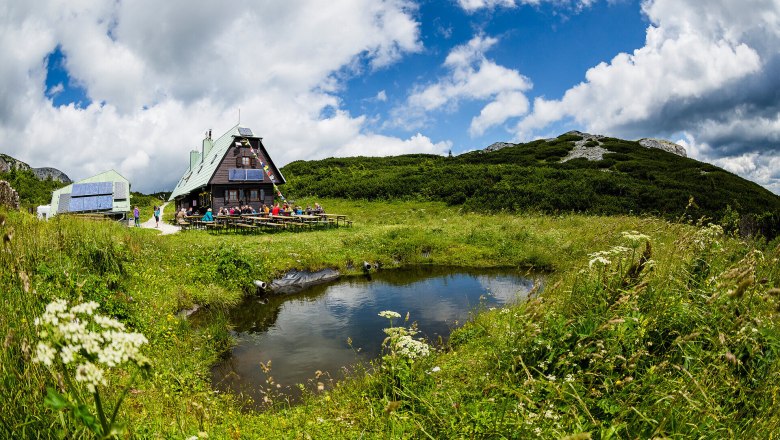 Surrounded by lush meadows and majestic mountains, the idyllic hut invites you to take a well-deserved rest. The clear air and the gentle lapping of the water create a harmonious atmosphere that captivates hikers.