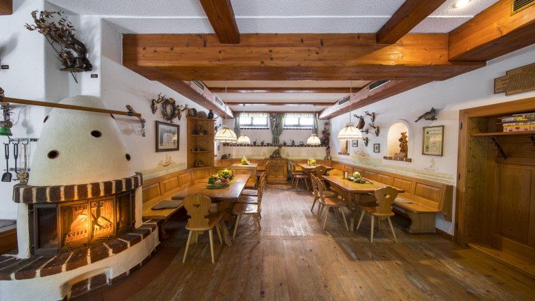 Cozy dining room with fireplace, wooden furniture and rustic decoration.
