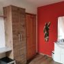 Room with red wall, wooden cupboard, washbasin and mirror.