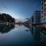 Modern buildings with water reflections at dusk.
