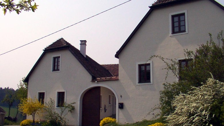 House, © Grünfelder A white country house with a brown roof and garden.