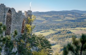 Ruin Türkensturz photographed from the side with a view of the hilly landscape and forests.