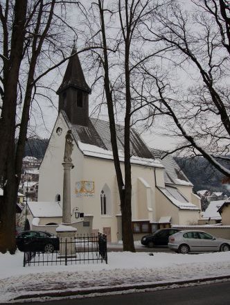 A church in winter with snow-covered ground and bare trees.
