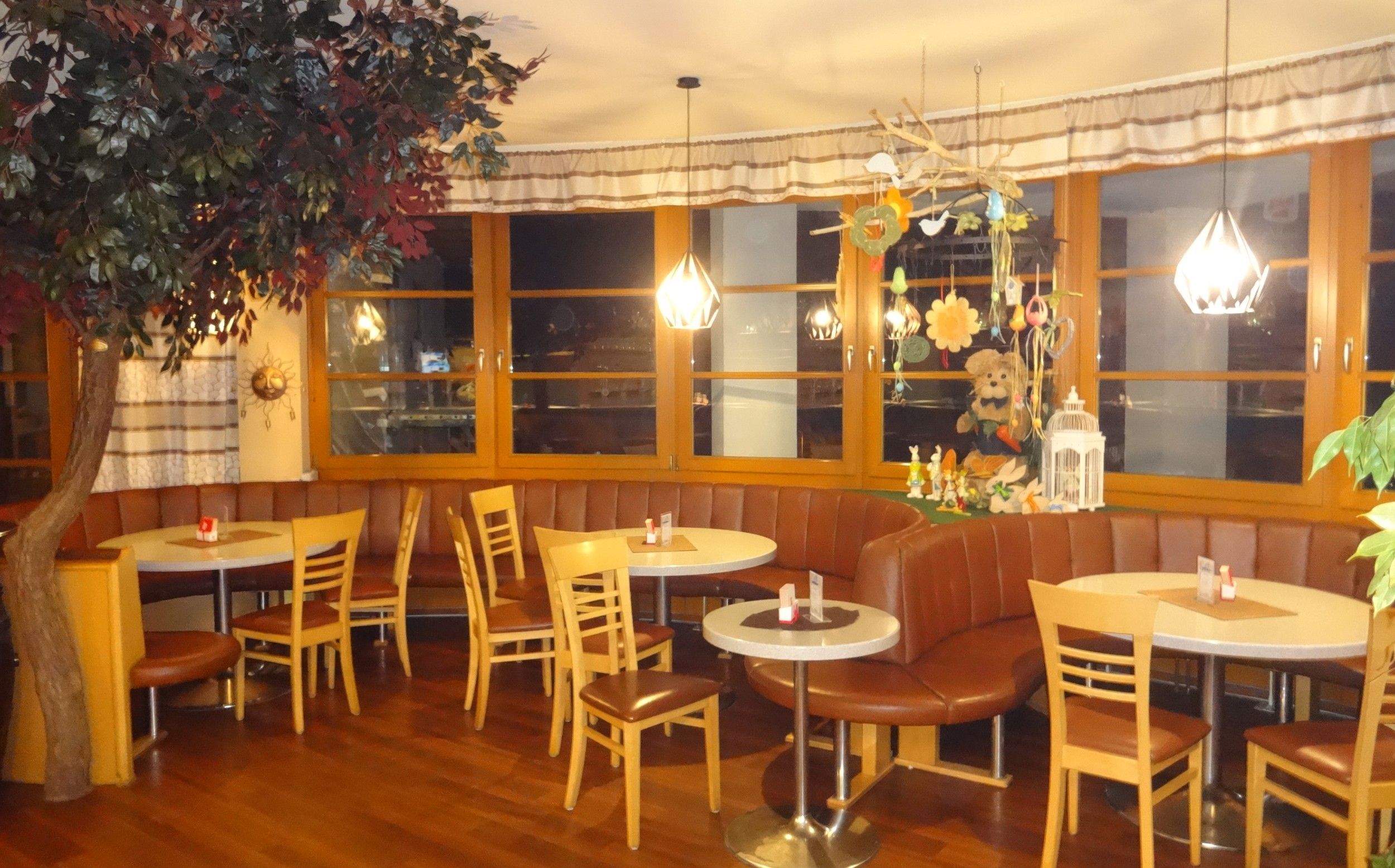 Cozy café with wooden furniture, decorations and plants.