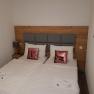 Double room with two single beds, gray headboard, pink sequin pillows and white bed linen.