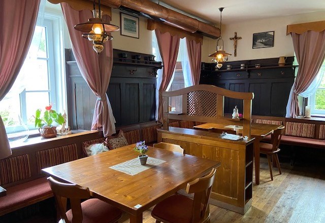 Cozy dining room with wooden furniture and pink curtains.