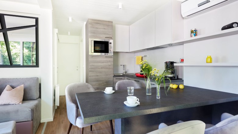 Dining table inside mobile home with flowers and cups
