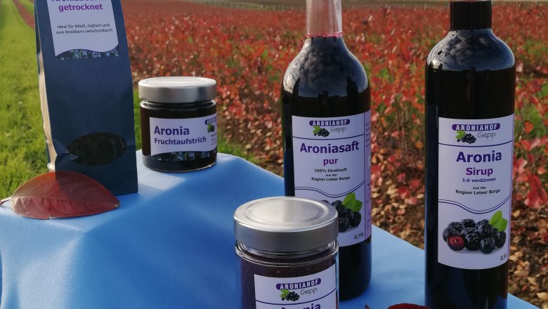 Products from Aroniahof Gepp on a table in front of a field.