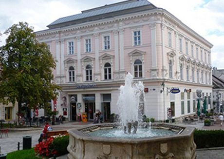 Historic building with fountain in the foreground.