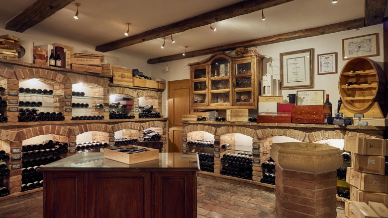 Wine cellar with brick shelves and wine bottles.