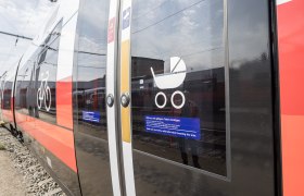 Close-up of a train door with symbols for bicycles and baby carriages.
