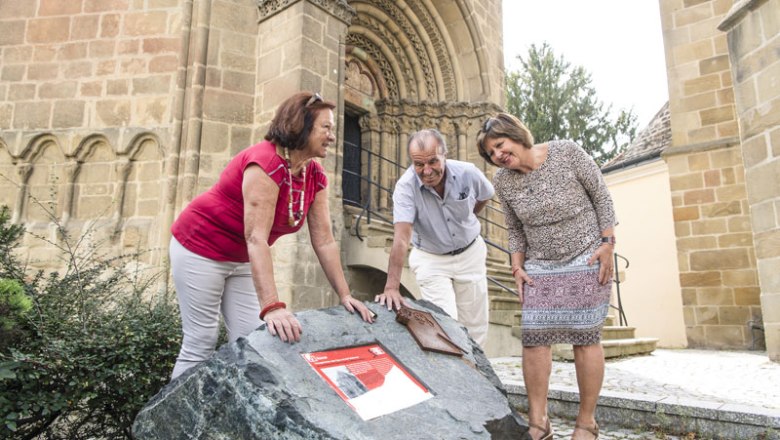Karner entrance portal with people in front of it 3 people