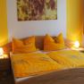 Cozy bedroom with yellow bed linen and warm light.