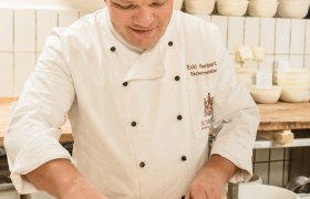 A master baker forms dough in a bakery.