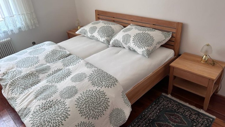Bedroom with double bed, wooden furniture and carpet.
