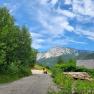 Driveway to a tiny house in a mountainous landscape with blue sky and clouds.