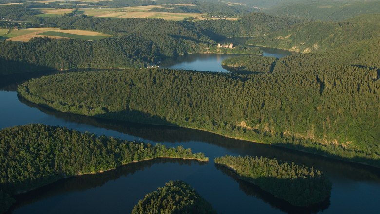 Aerial view of the Dobra reservoir with surrounding forests and hills.