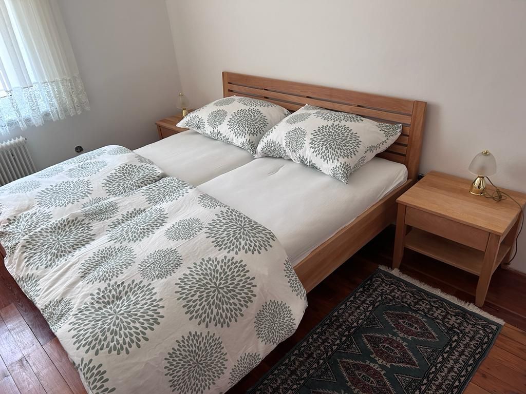 Bedroom with double bed, wooden furniture and carpet.