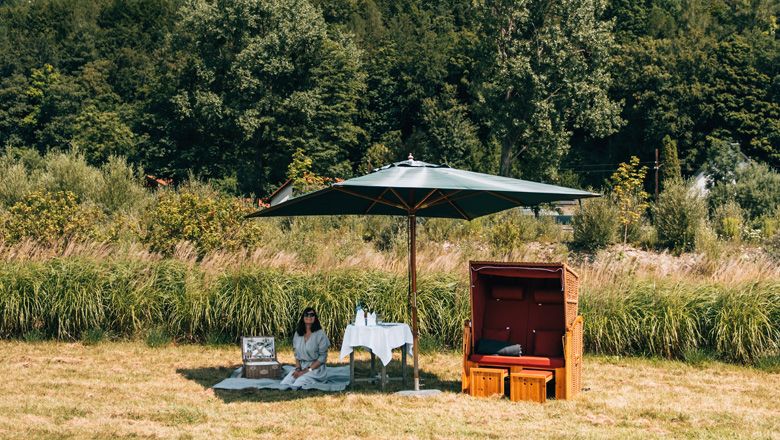 Picnic by the river with parasol and beach chair 