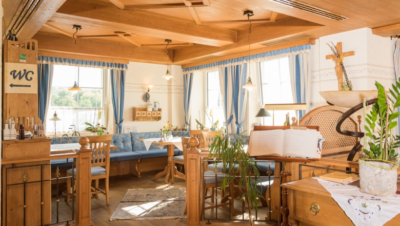 Cozy restaurant area with wooden furniture and blue curtains.