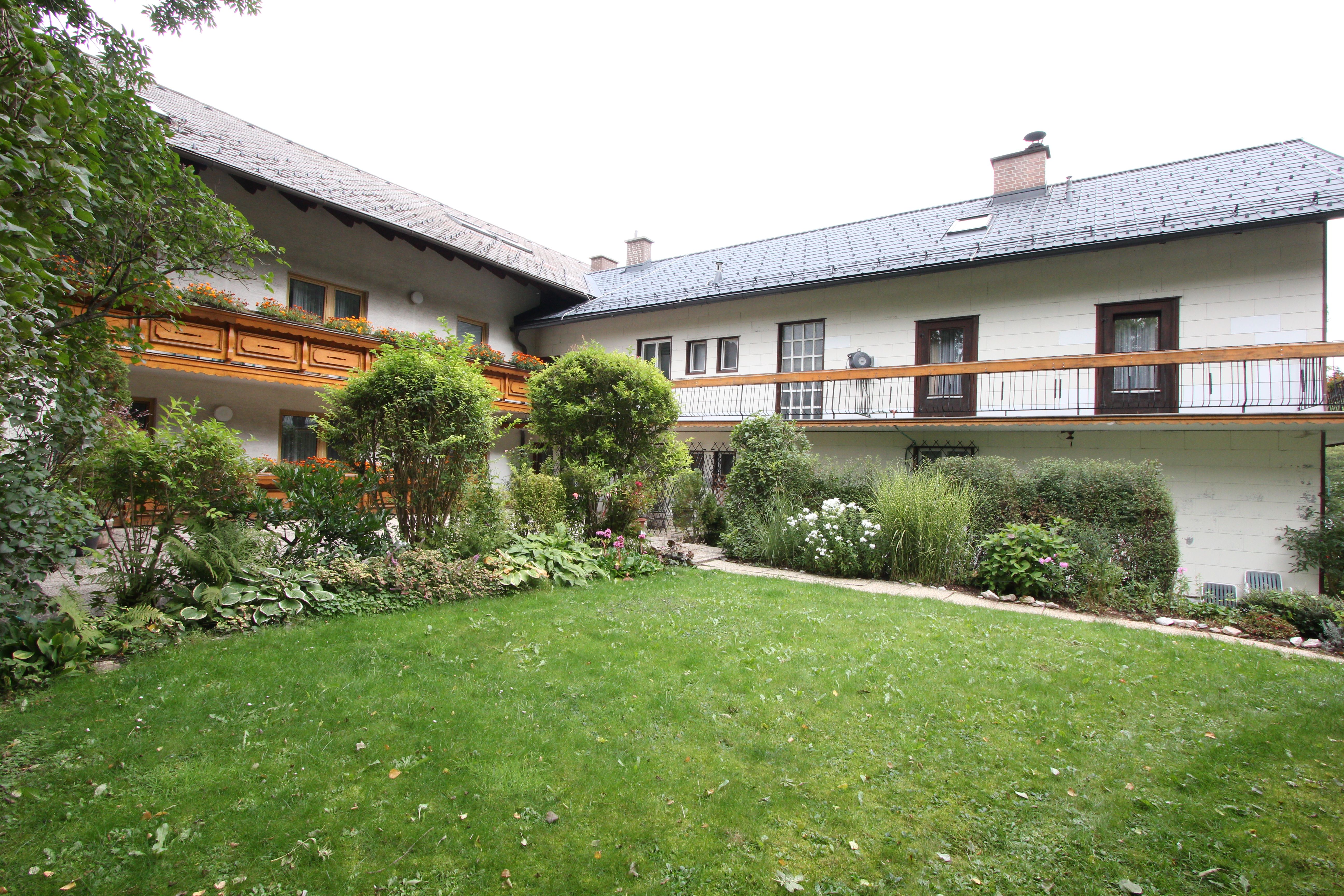 A traditional house with wooden balcony and well-kept garden.