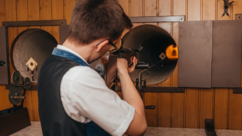 Person aims a rifle at a shooting range.