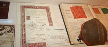 Historical documents and a hat on display in a showcase.