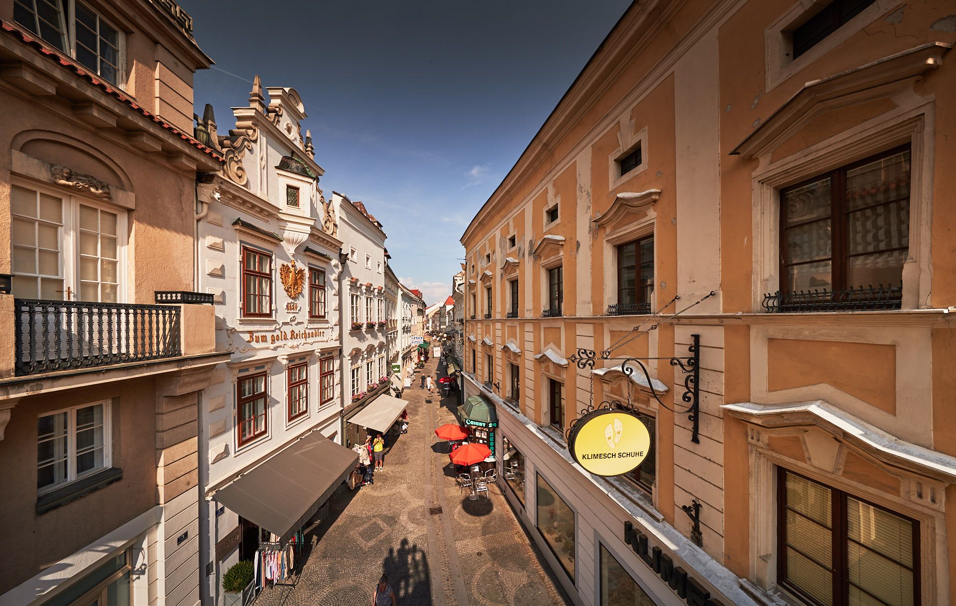 View of a historic street in the old town of Krems with old buildings and stores.