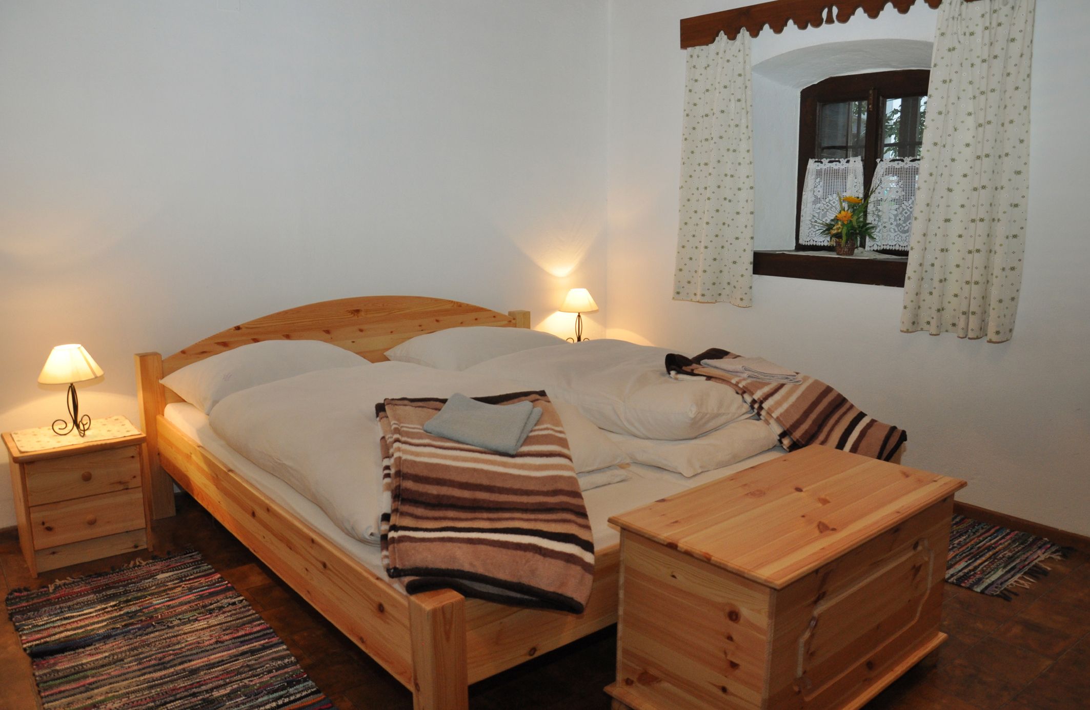Cozy bedroom with wooden furniture and double bed.