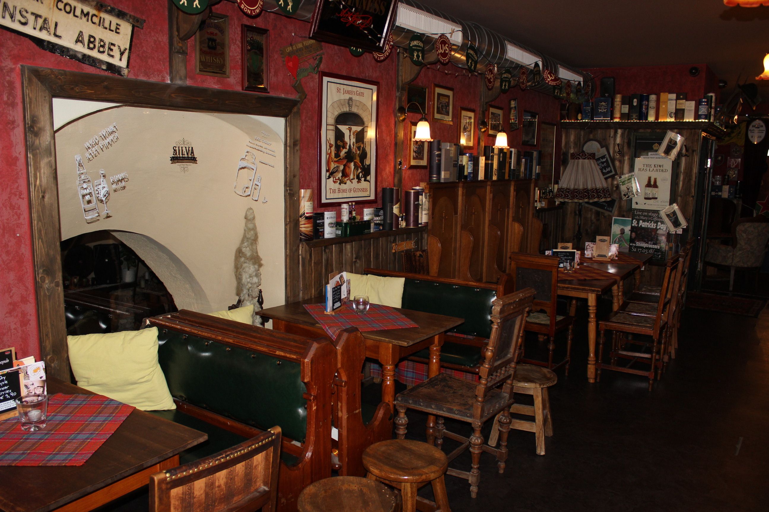 Cozy bar with wooden furniture, red walls and Irish decorations.