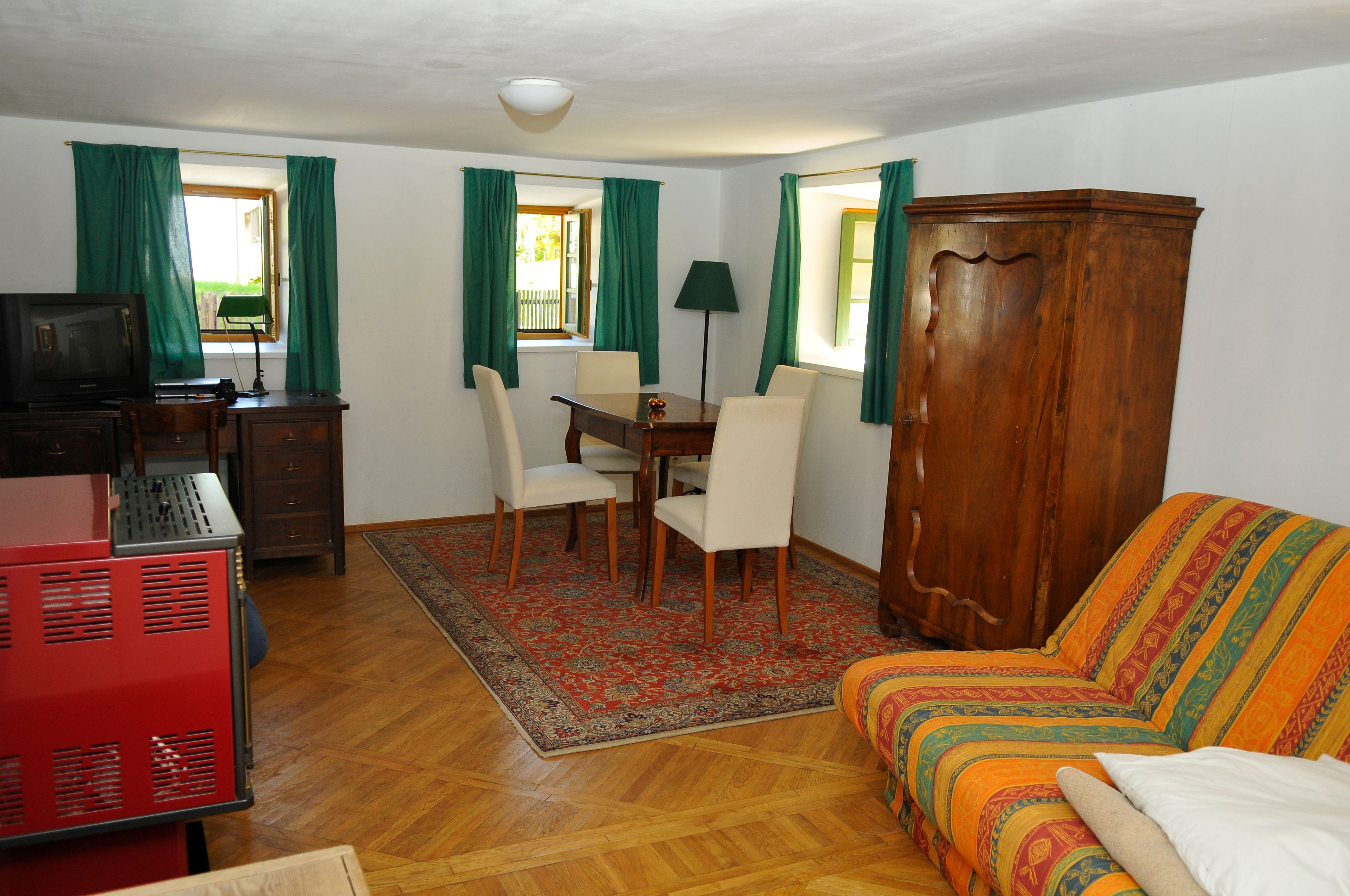 Cozy guest room with wooden furniture, carpet and sofa.