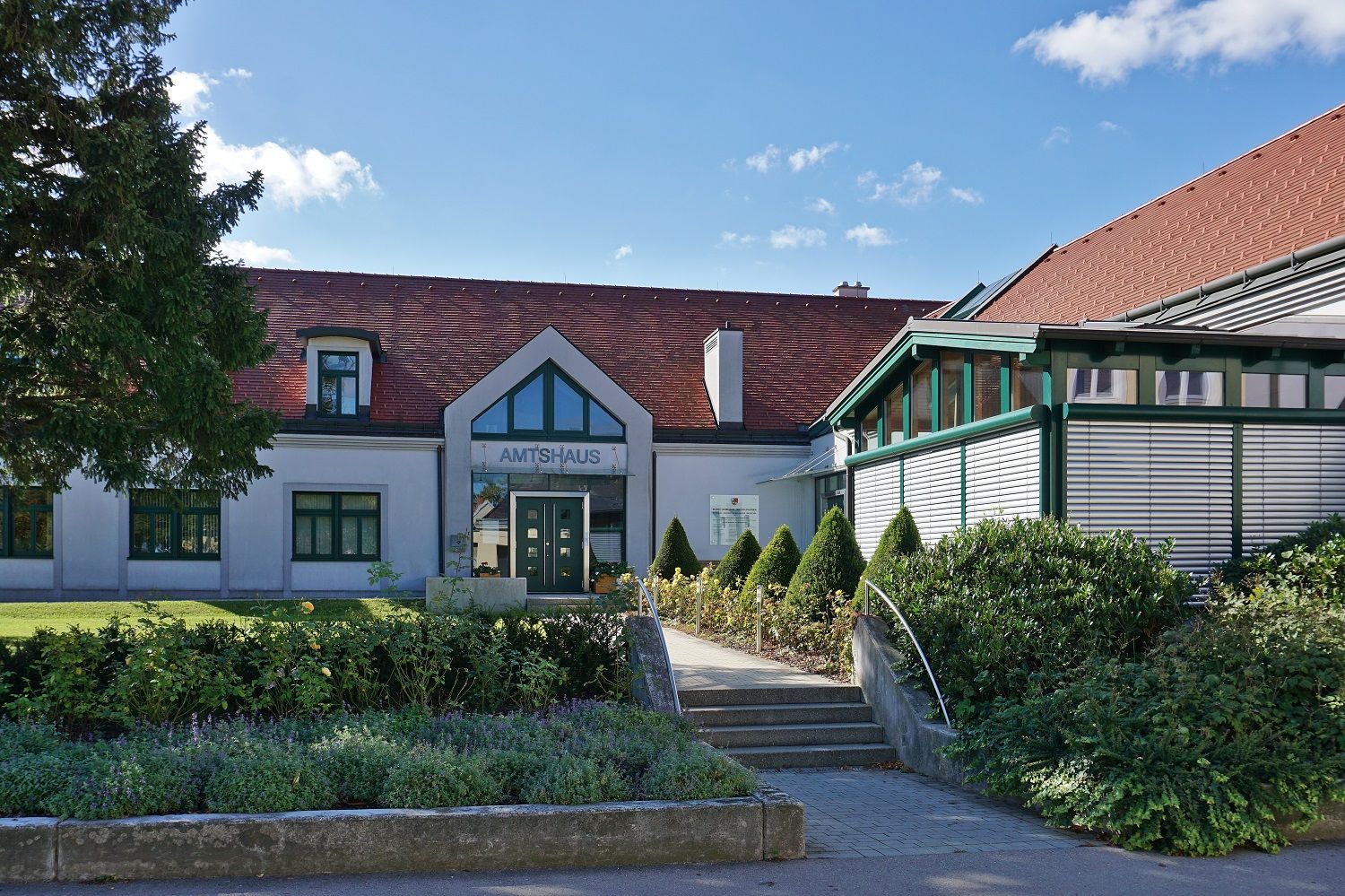 Official building with red roof and garden in Michelhausen.