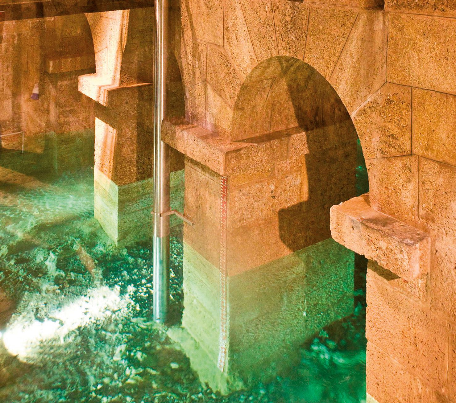 Stone arches over flowing water in the Kaiserbrunn Water Pipeline Museum.
