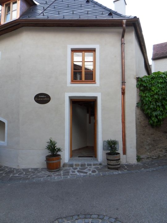 Open front door of a historic building with two flower troughs on the left and right