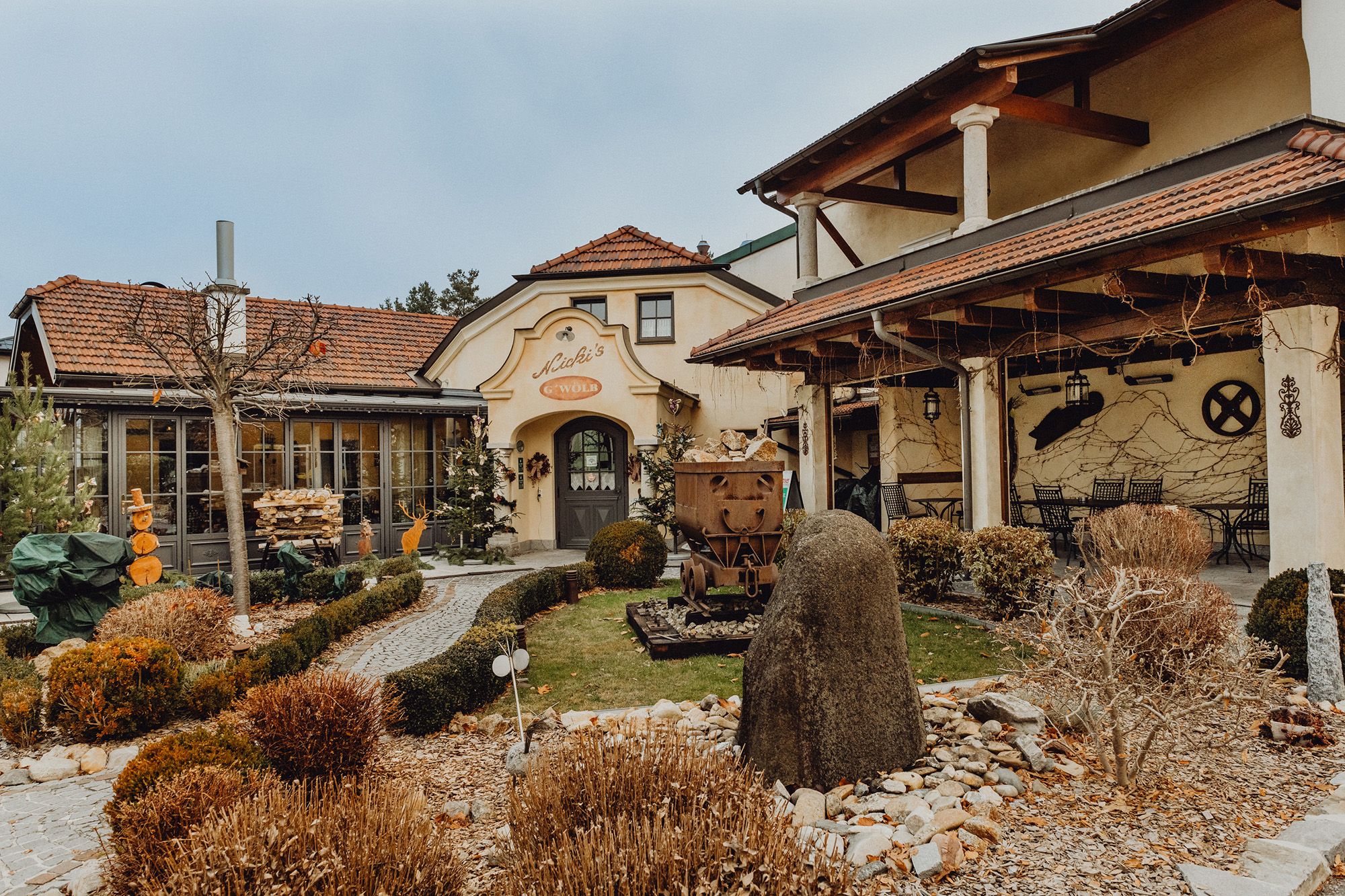 Exterior view of a traditional inn with garden and decorations.