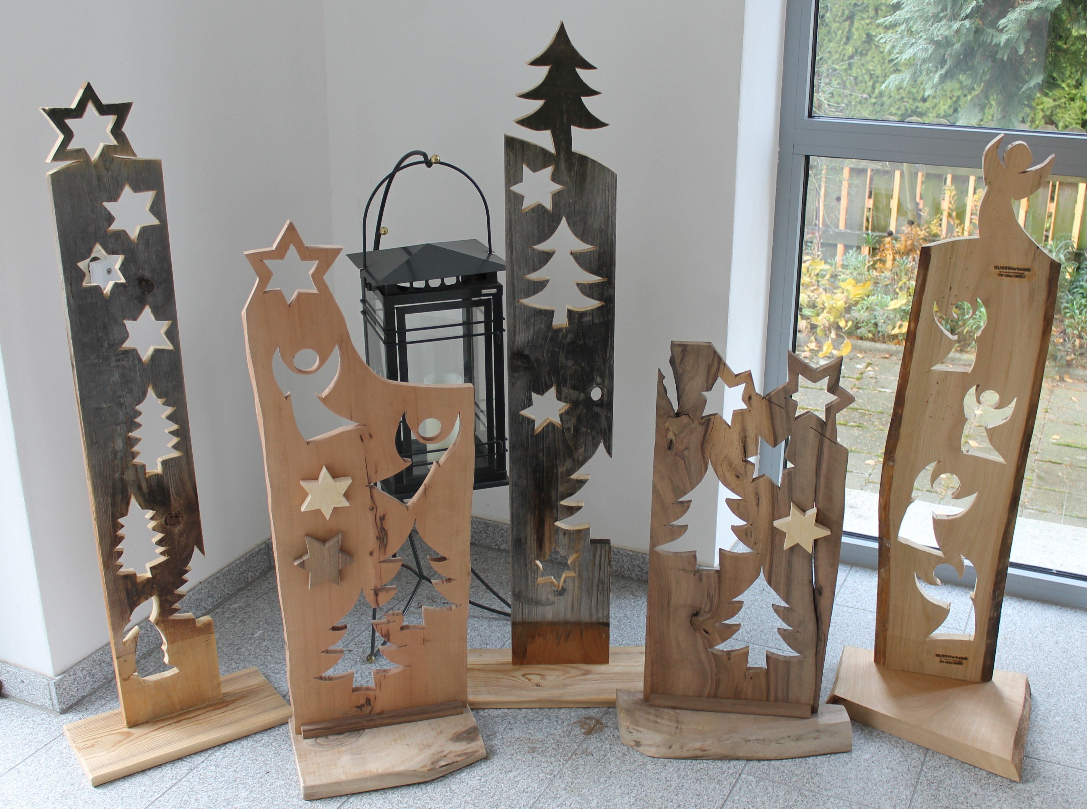 Wooden decorations with stars and angels in front of a window.