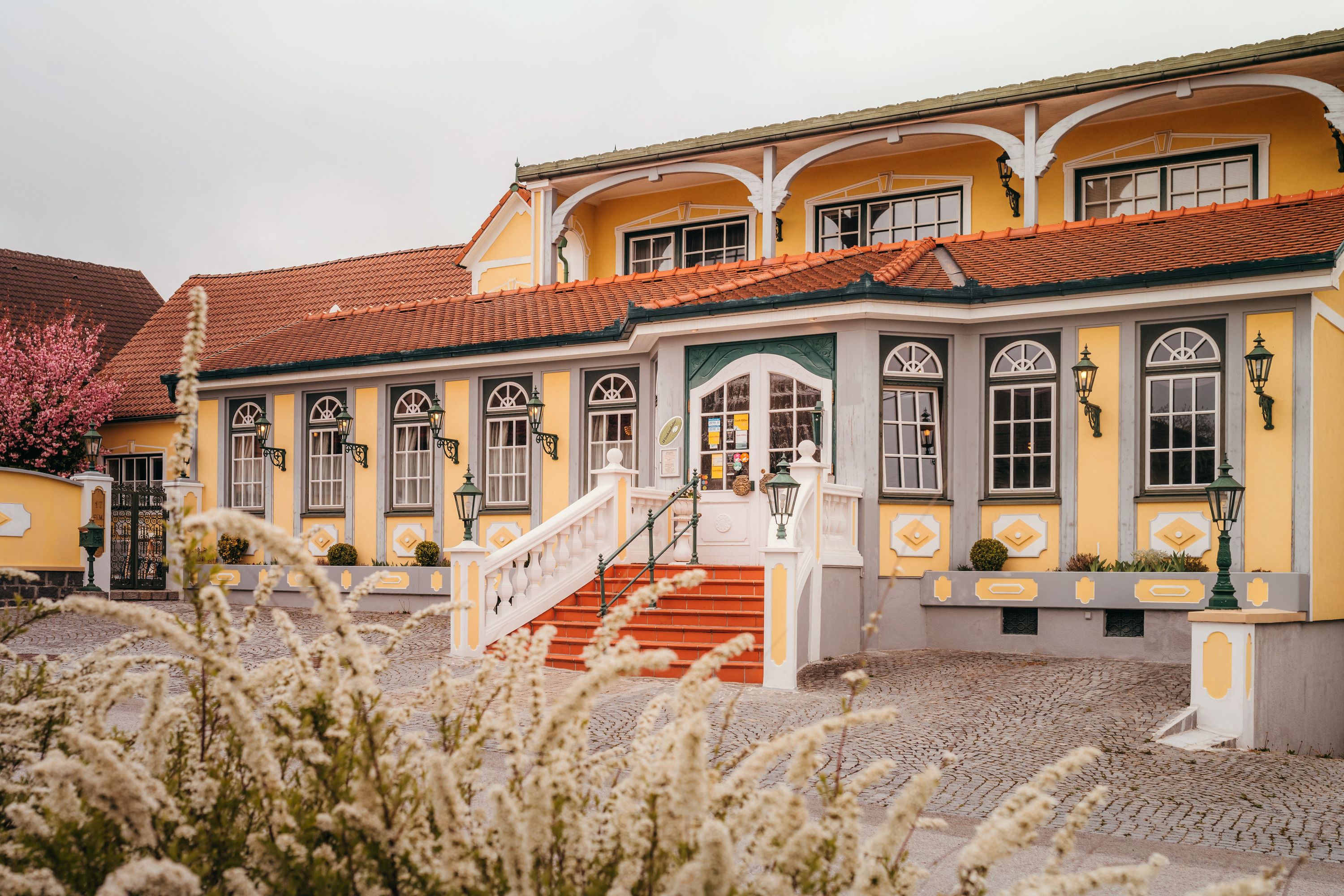 A yellow country inn with red roof tiles and white stairs in Vitis.