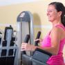Woman exercising on a cross trainer in the gym.