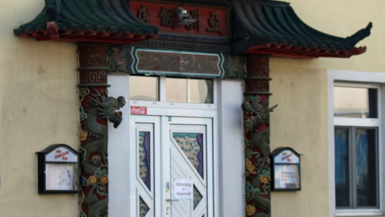 Entrance to a Chinese restaurant with a traditional Chinese roof and decorative pillars.