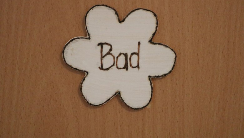 Wooden sign in the shape of a flower with the inscription 'Bad'.