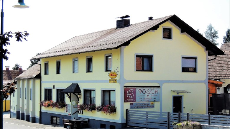 Yellow inn with flower boxes and sign 'Posch'.
