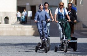 People ride three-wheeled scooters in Mariazell.