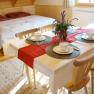 Cozy room with double bed and dining table, set for four people.