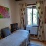 Single room with bed, window, curtains and wall decorations.