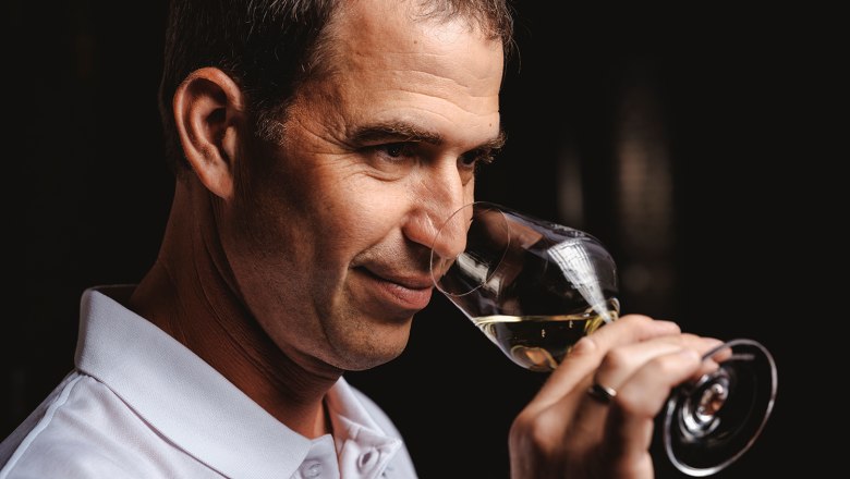 Person smells a glass of white wine.