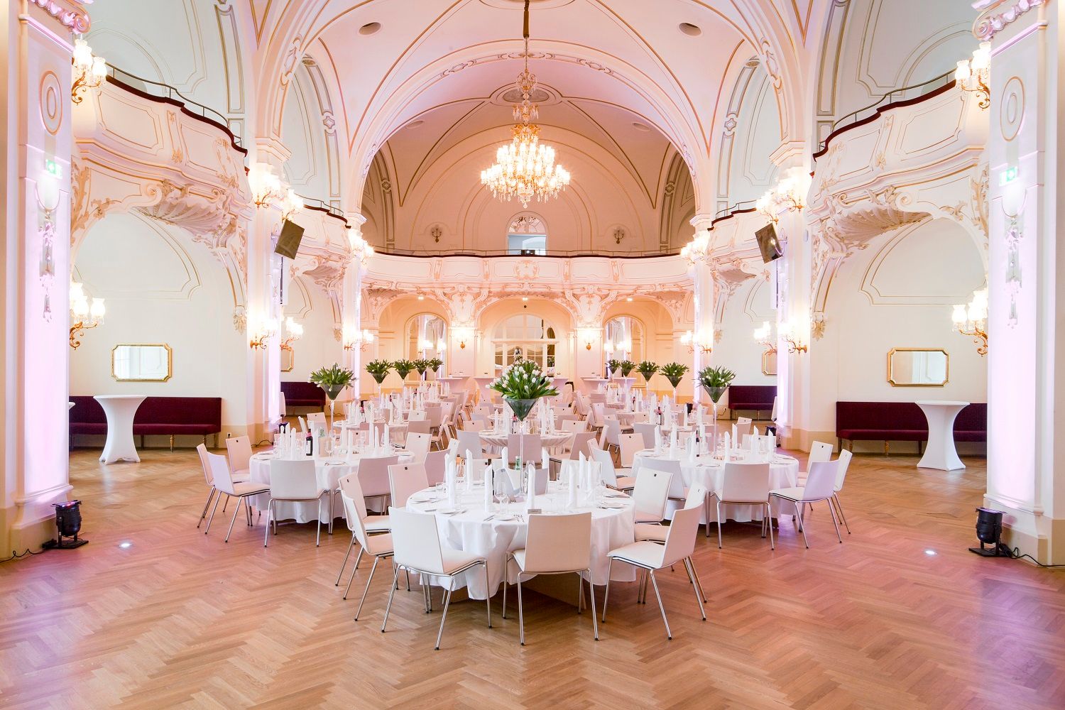 Elegant hall with laid tables and chandeliers.