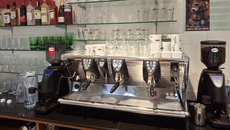 Coffee machine with cups and glasses in a caf&eacute;.