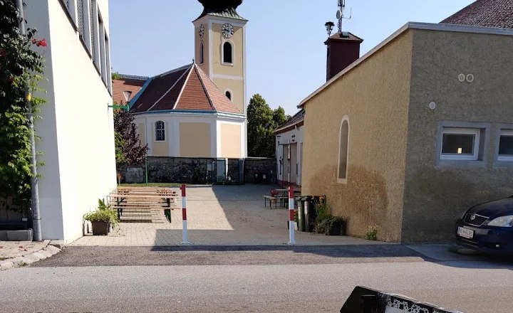 Buschenschank (typical tavern) Thaller Wolfsthal, view into the courtyard with wine tables, in the background you can see a church